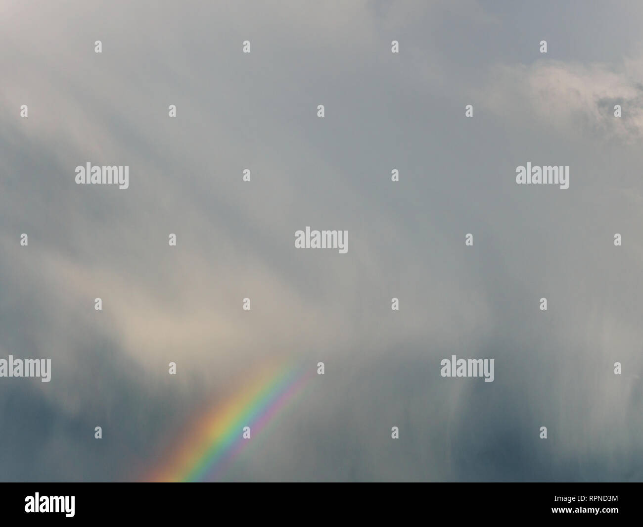 rainbow on the dramatic sky and the sun's rays Stock Photo