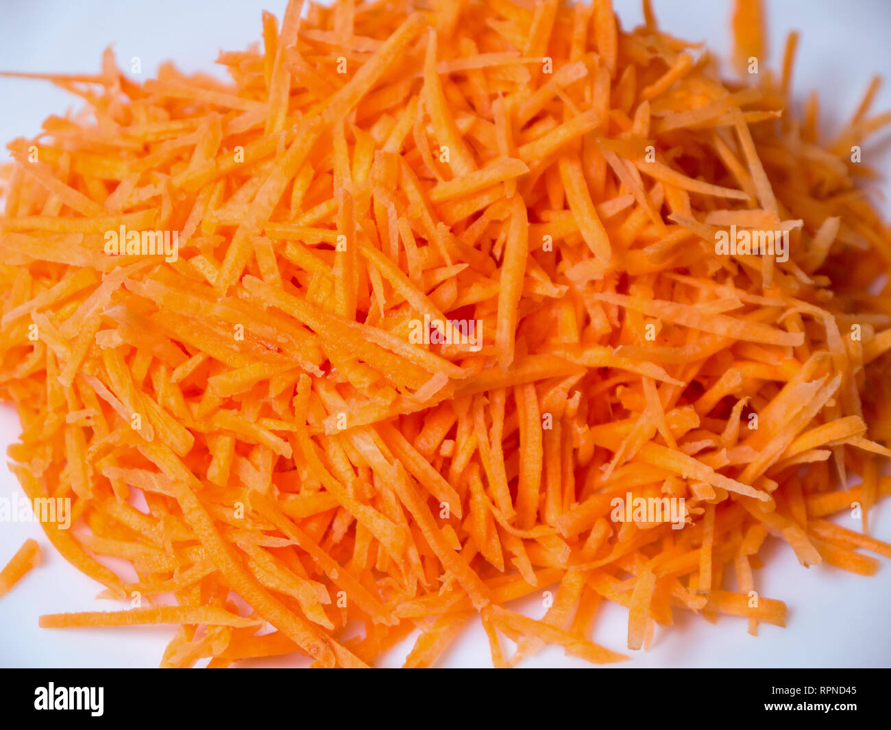 fresh winter carrot cut in julienne on a white background Stock Photo