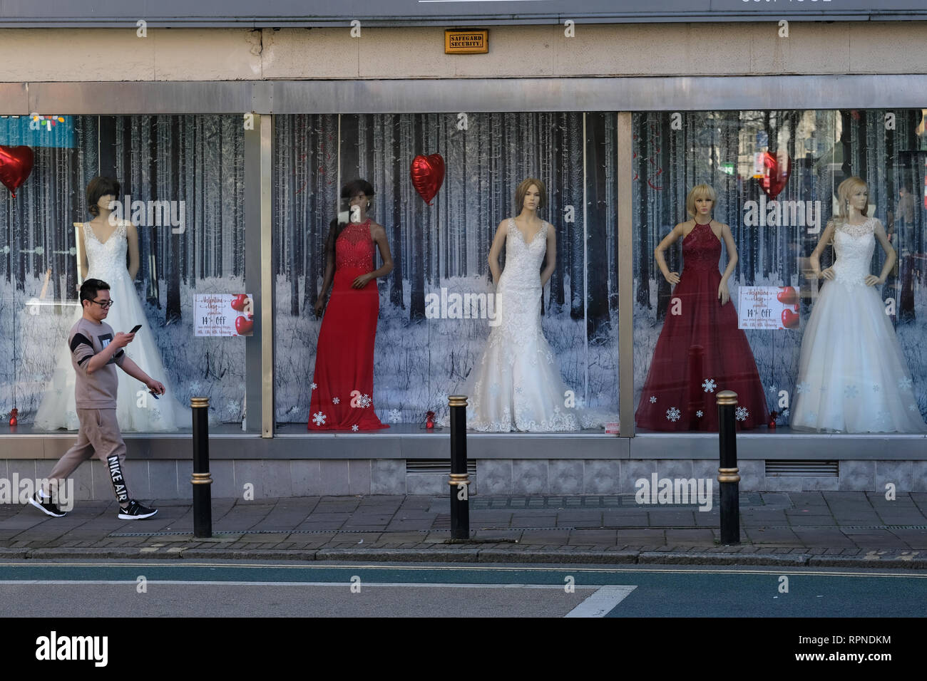 A man walks past a wedding dress shop in Exeter, UK. Stock Photo