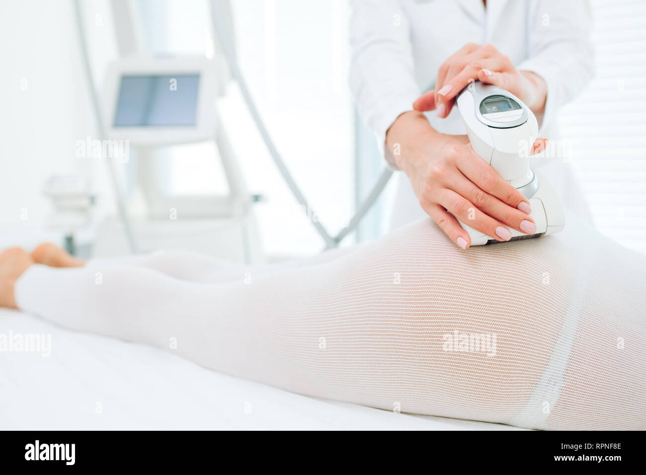 close up of female back and buttocks, in white LPG slimming bodysuit