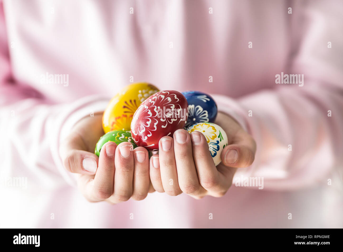 Close-up multicolored easter eggs in the girls hands. Stock Photo