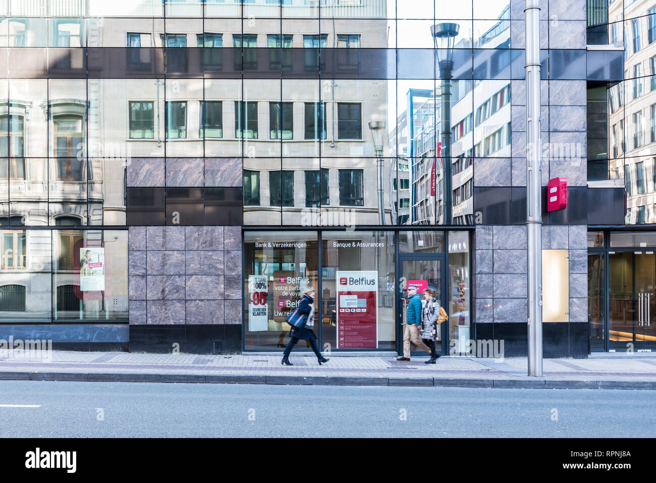 City of Brussels / Belgium - 02 15 2019: Facade of a large Belfius banking and insurance agency with steel and glass, reflecting the oppositie side of Stock Photo