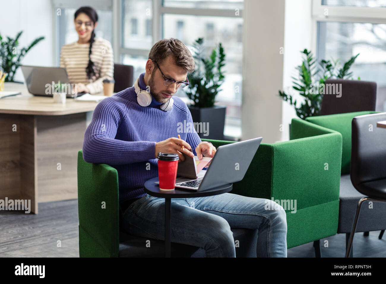Serious bearded male making notes in copybook Stock Photo