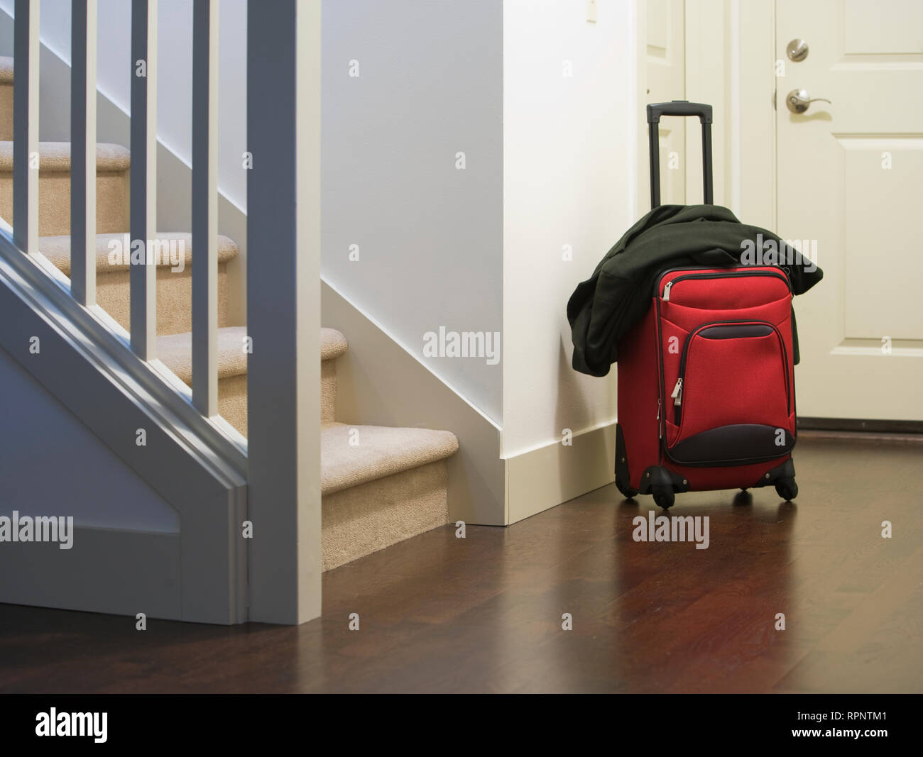 Suitcase and jacket in house foyer Stock Photo Alamy