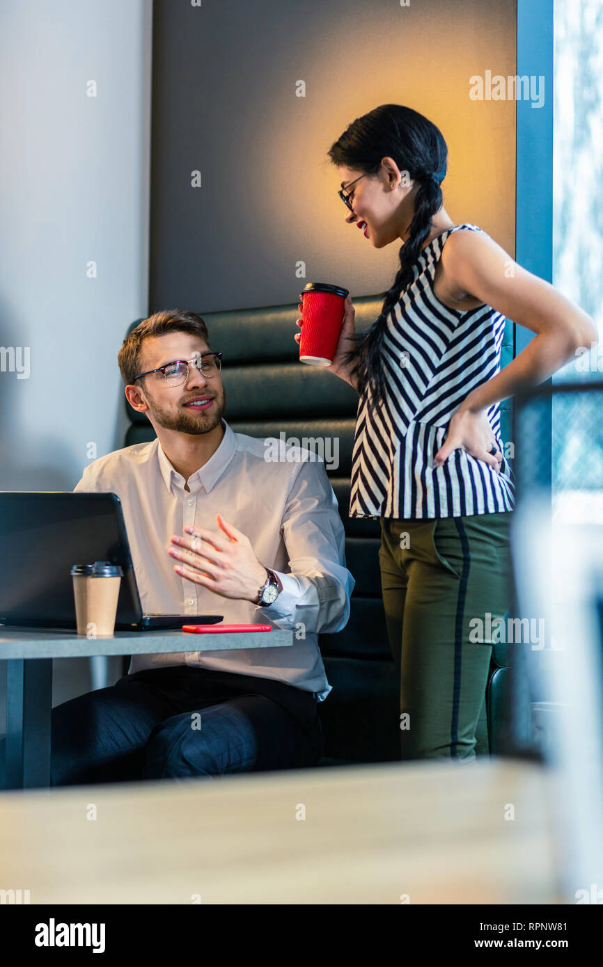 Cheerful bearded programmer talking to his colleague Stock Photo
