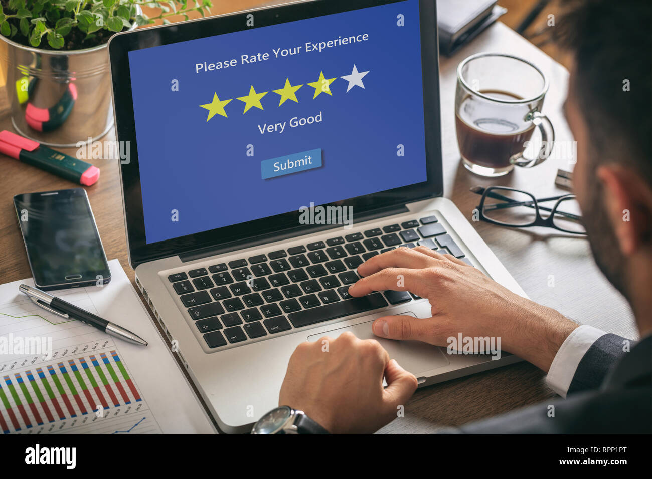 Customers service rating. Man working with a computer, 4 stars, very good text on the screen, office background Stock Photo