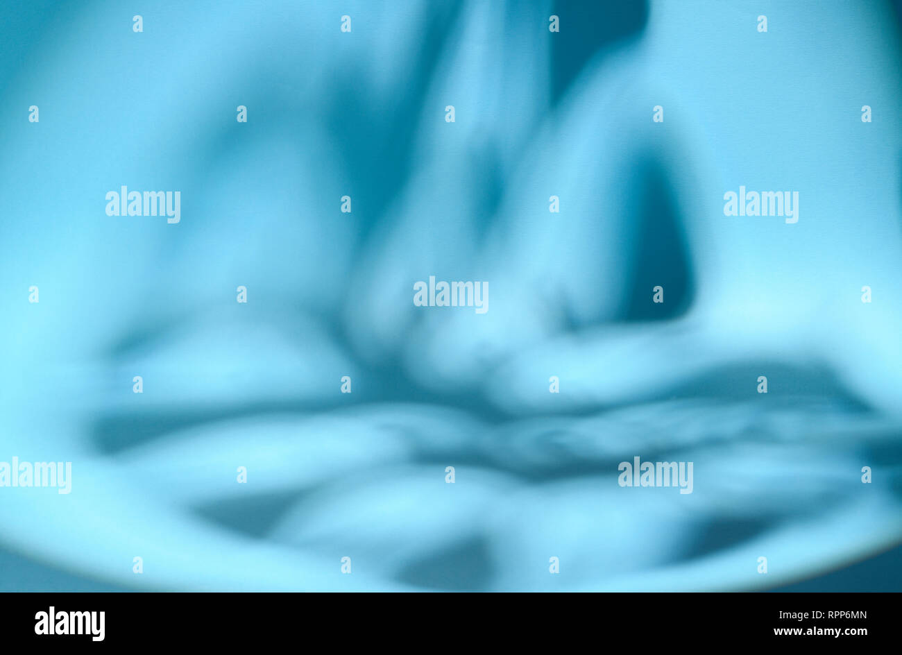 Shaded area in the shape of a tropical leaf. Dappled light. Blue background. Stock Photo