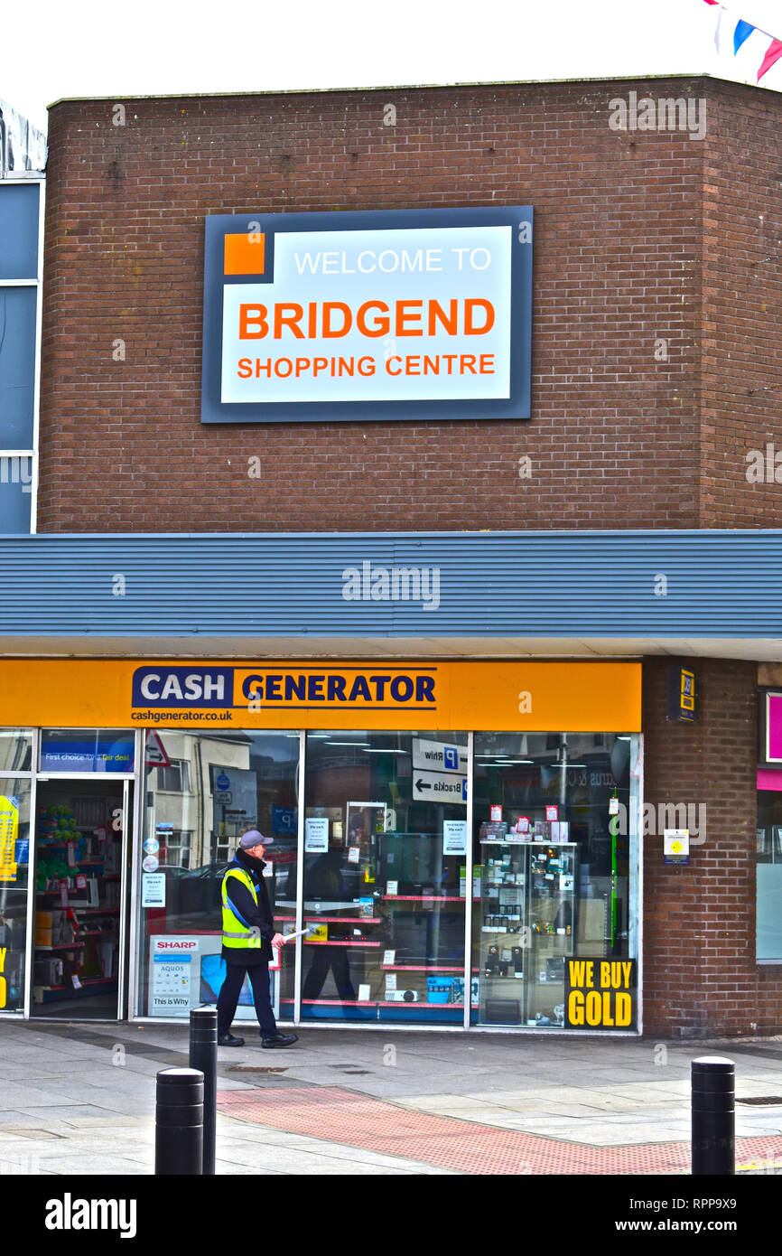 Welcome Sign outside the modern Bridgend Shopping Centre, above the Cash Generator Man in high vis walking past Stock Photo - Alamy