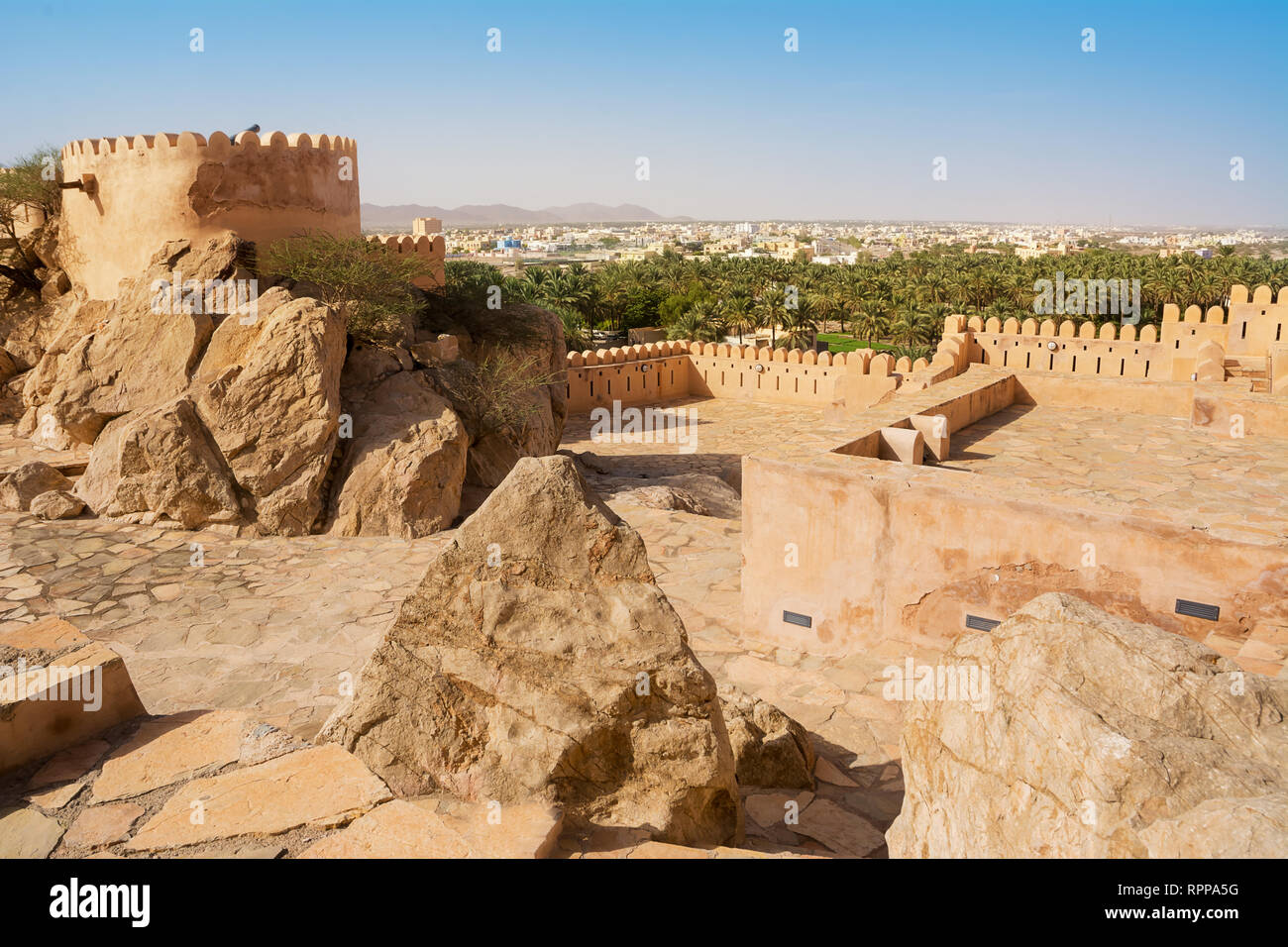 Walls of the Fort of Nakhal and the village with the mosque in the background (Oman) Stock Photo