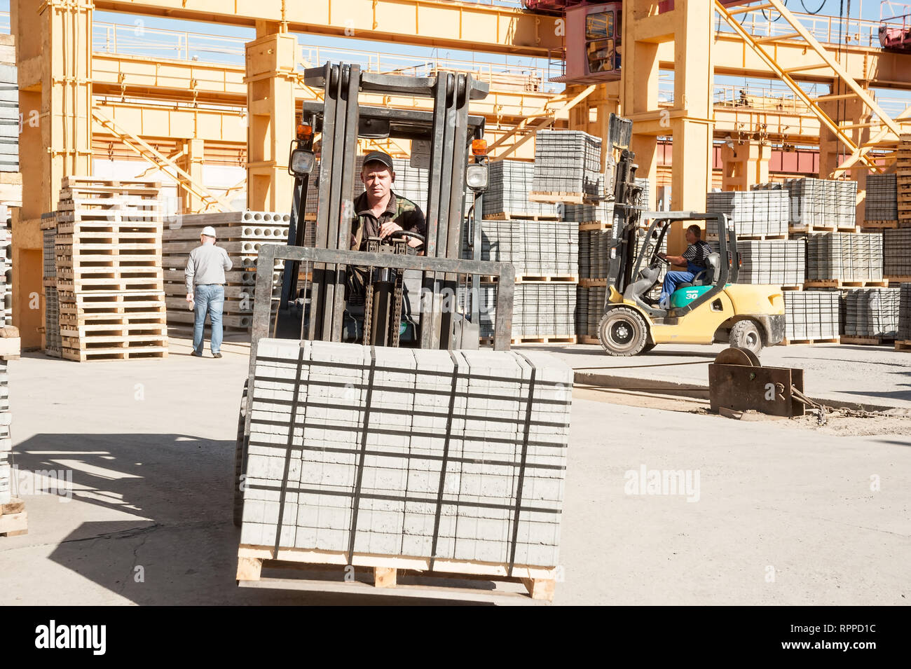 Driver on lift truck loads products of plant Stock Photo Alamy