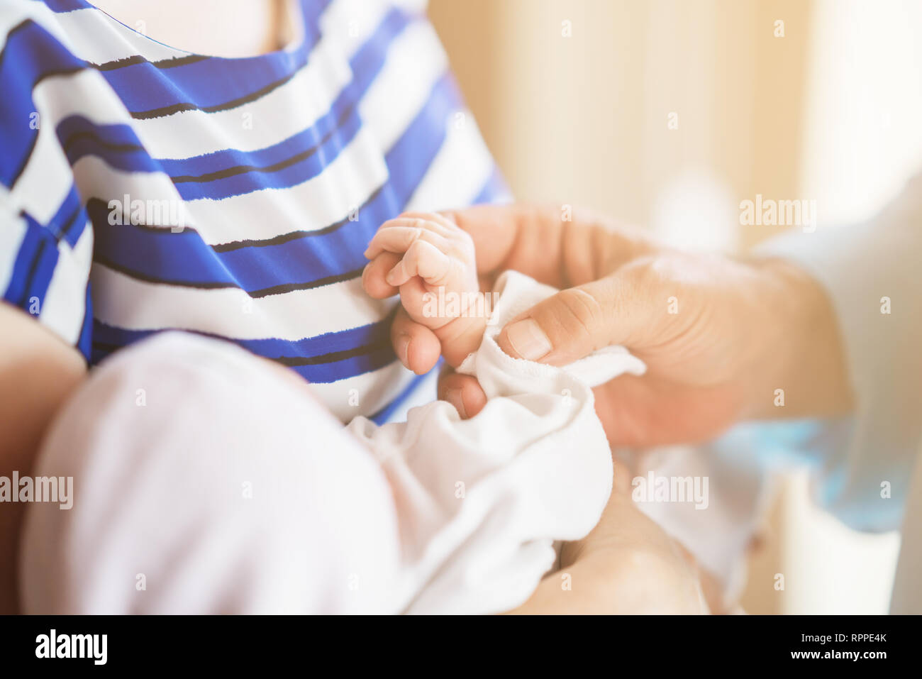 Family Baby Hands. Father and Mother Holding Newborn Kid. Child Hand Closeup into Parents Stock Photo