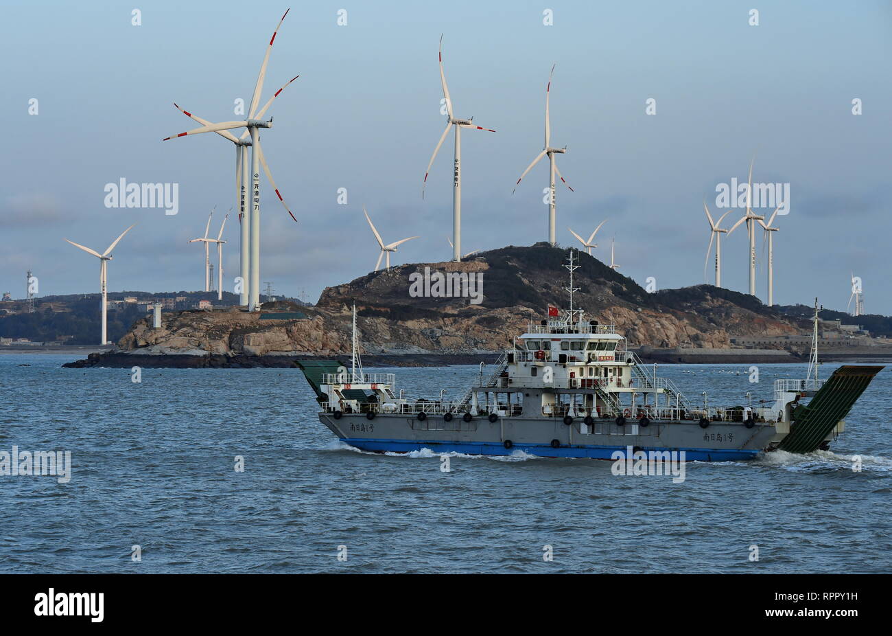 Putian, China's Fujian Province. 22nd Feb, 2019. A ship sails in the waters of Nanri Island with a wind farm in the background in Putian, southeast China's Fujian Province, Feb. 22, 2019. Nanri Island has seen faster growth in the construction of wind power plants in recent years and 138 wind power generators have been put into operation. Credit: Zhang Guojun/Xinhua/Alamy Live News Stock Photo