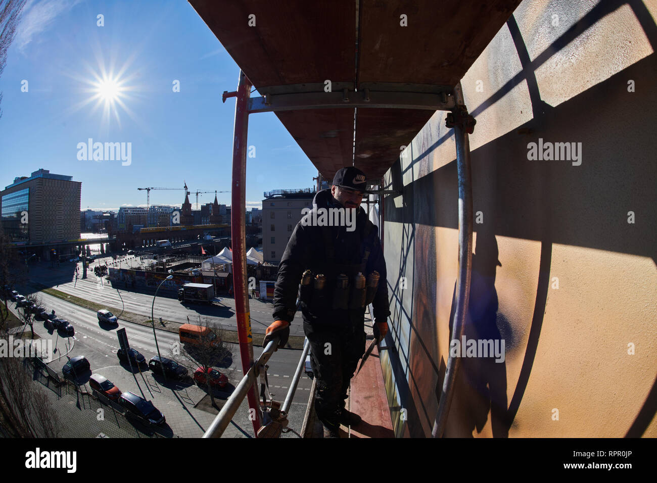 Berlin, Germany. 22nd Feb, 2019. The artist Tank is standing on the scaffold high above, opposite the East-Side Gallery. Together with the Berlin artist collective Die Dixons, he paints the oversized Mona Lisa on the windowless façade of the East Side Hotel. Credit: Annette Riedl/dpa/Alamy Live News Stock Photo