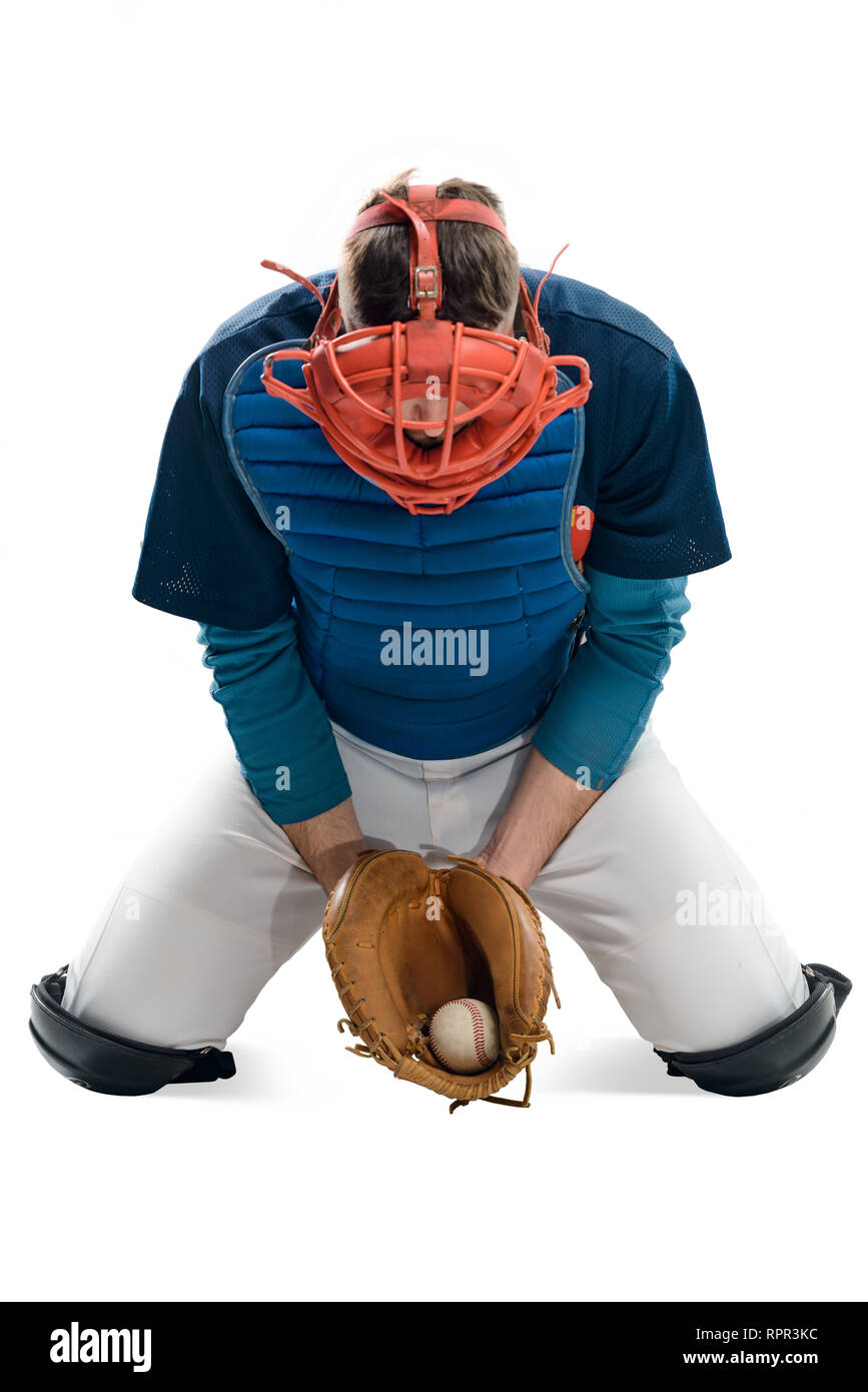 Baseball player caught a ball with a leather mitt. Man dressed in a uniform and wearing a gear, sitting on his knees. Stock Photo