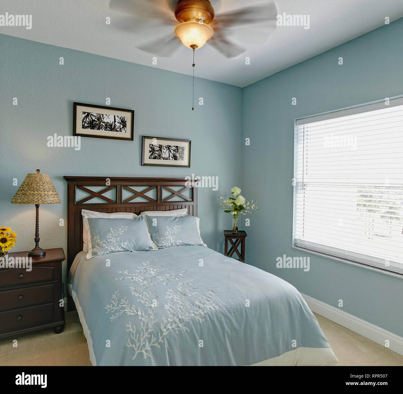 Ceiling fan over bed in bedroom Stock Photo Alamy