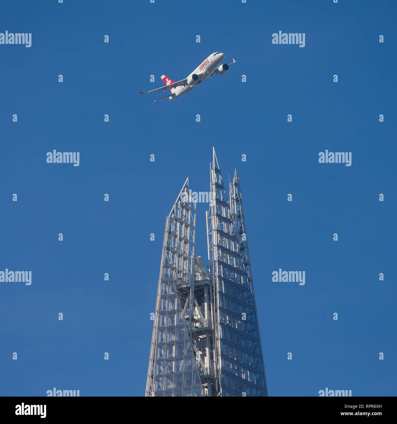 A Swiss airlines plane banks above the Shard on approach to LCY City airport. Stock Photo