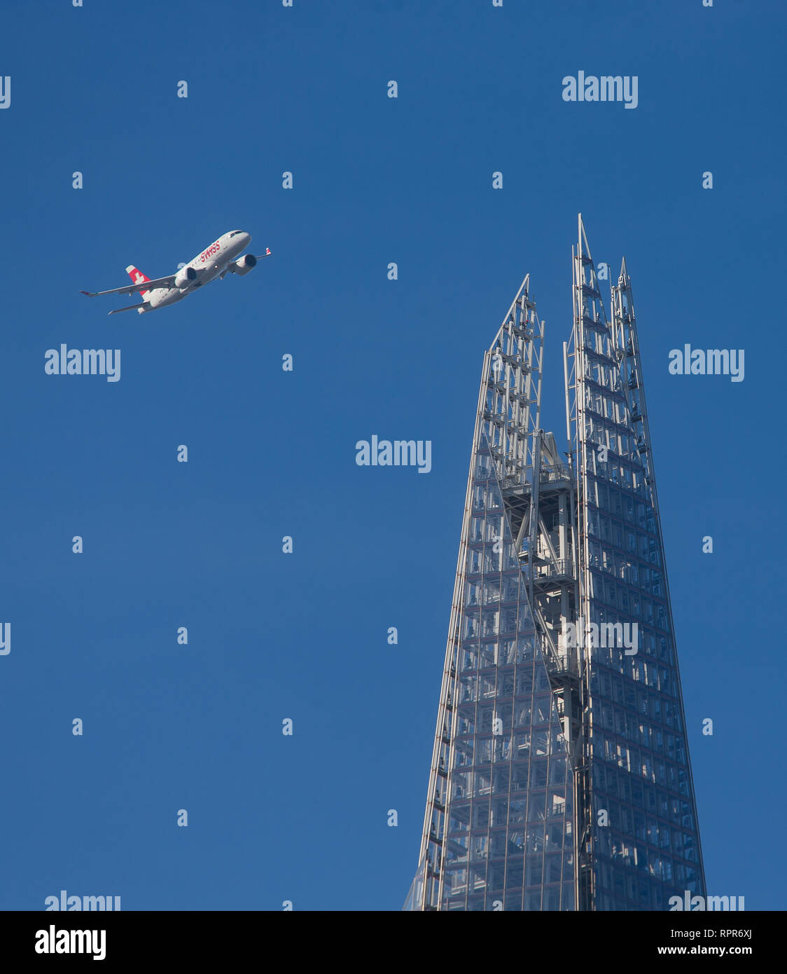 A Swiss airlines plane banks above the Shard on approach to LCY City airport. Stock Photo