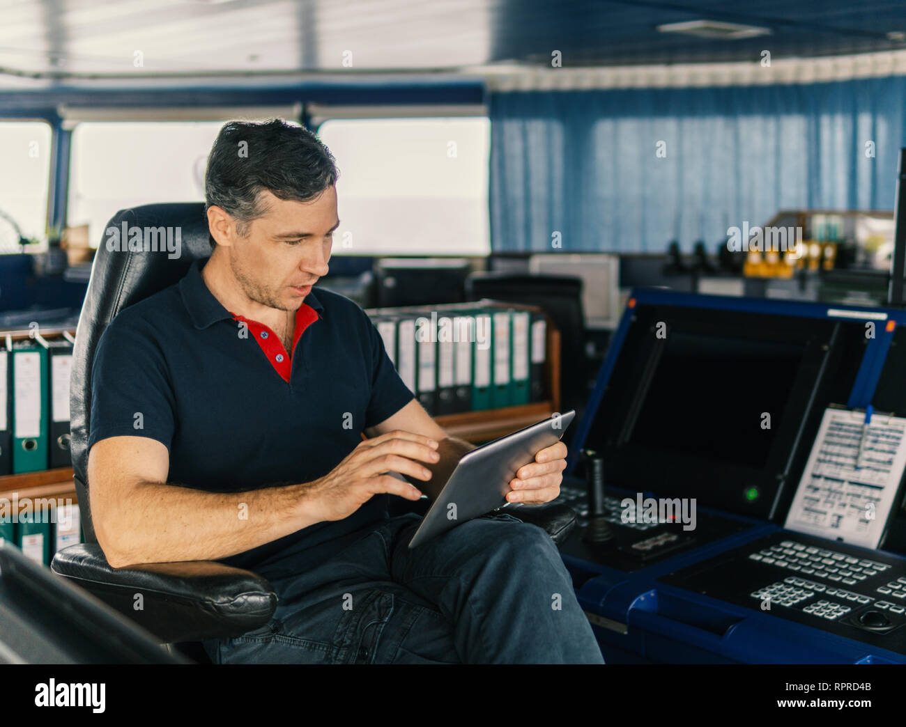 chief officer on navigation bridge watching digital tablet Stock Photo ...