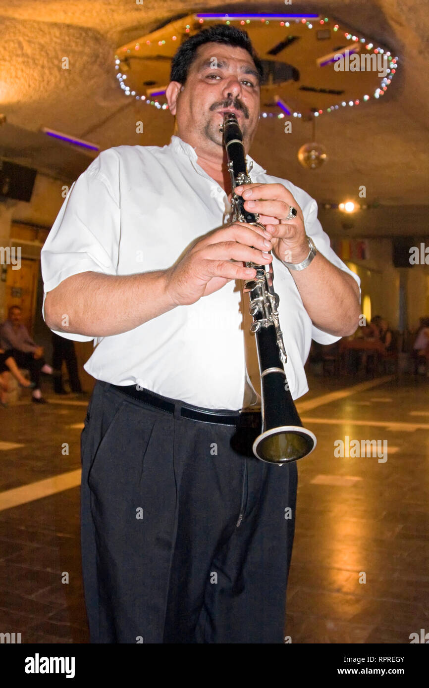 man playing clarinet; musician; entertainment; talent, job, occupation, subdued lighting, woodwind, instrument, clarinetist, Turkey; vertical Stock Photo