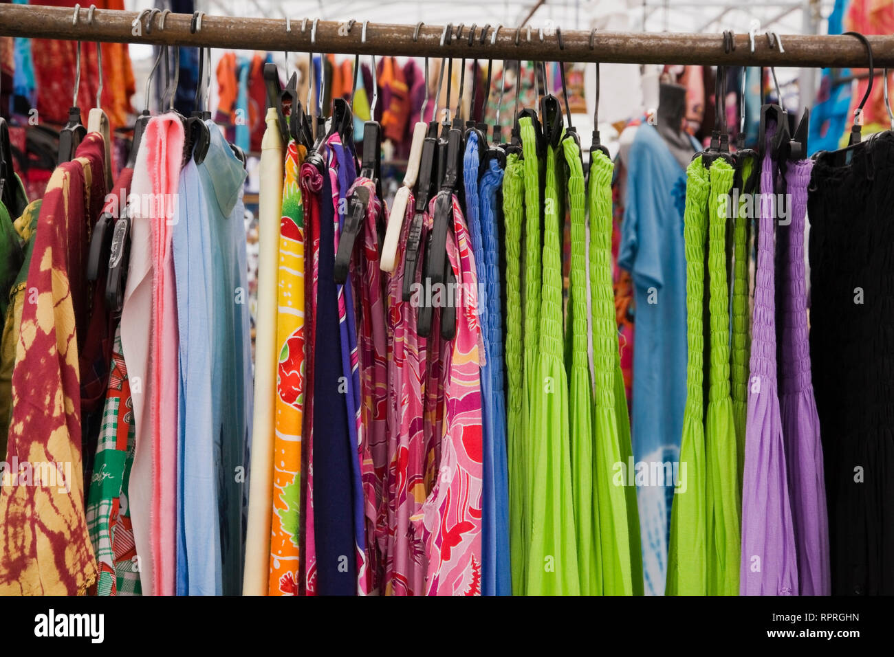 Women's cotton dresses for sale on a clothes rack at an outdoor market Stock Photo