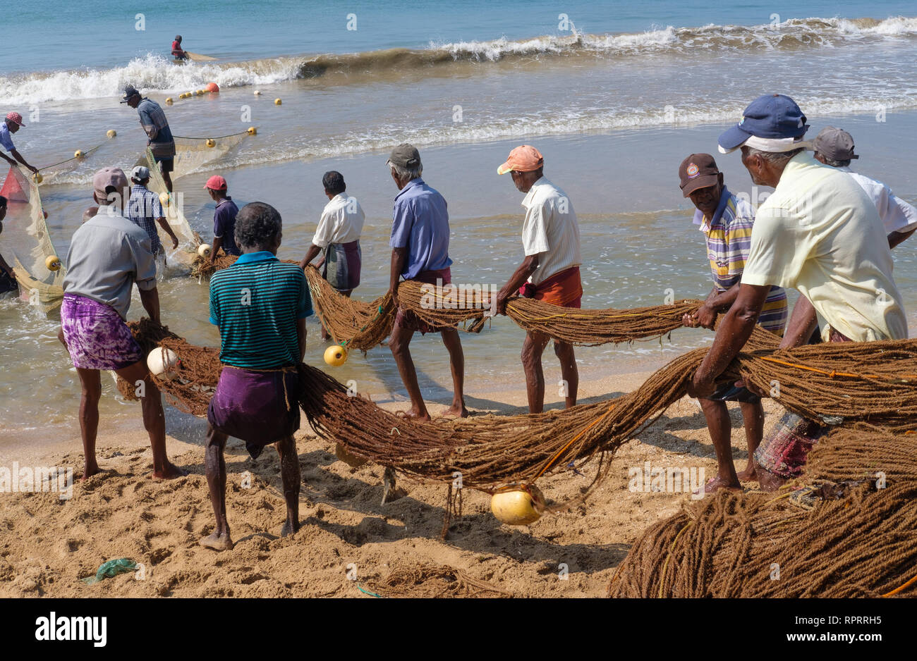 Fishermen haul in a net on the beach in Galle, Sri Lanka Stock Photo