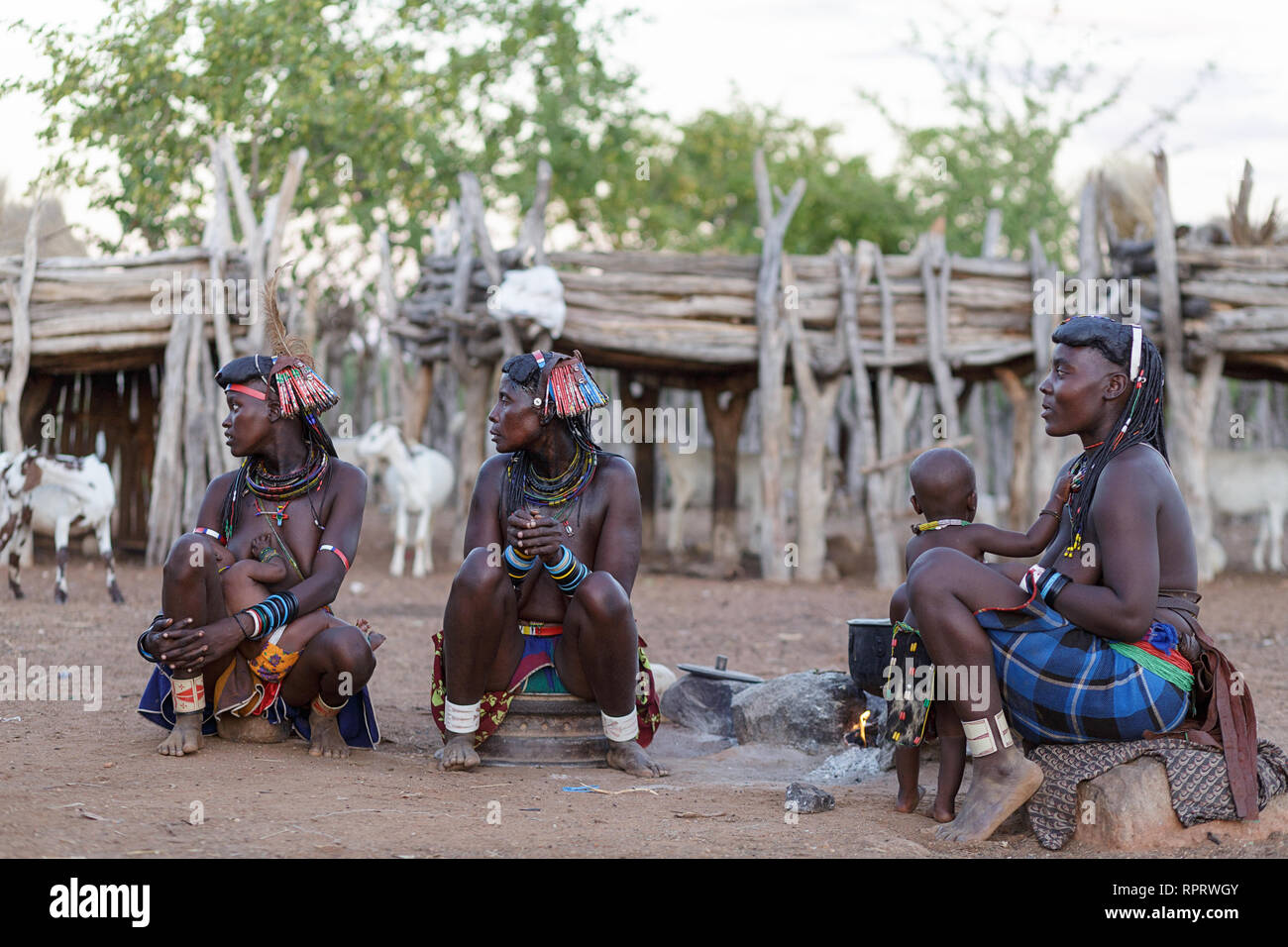 People from Zemba tribe sitting around fire in a traditional village near Epupa, Namibia, Africa Stock Photo