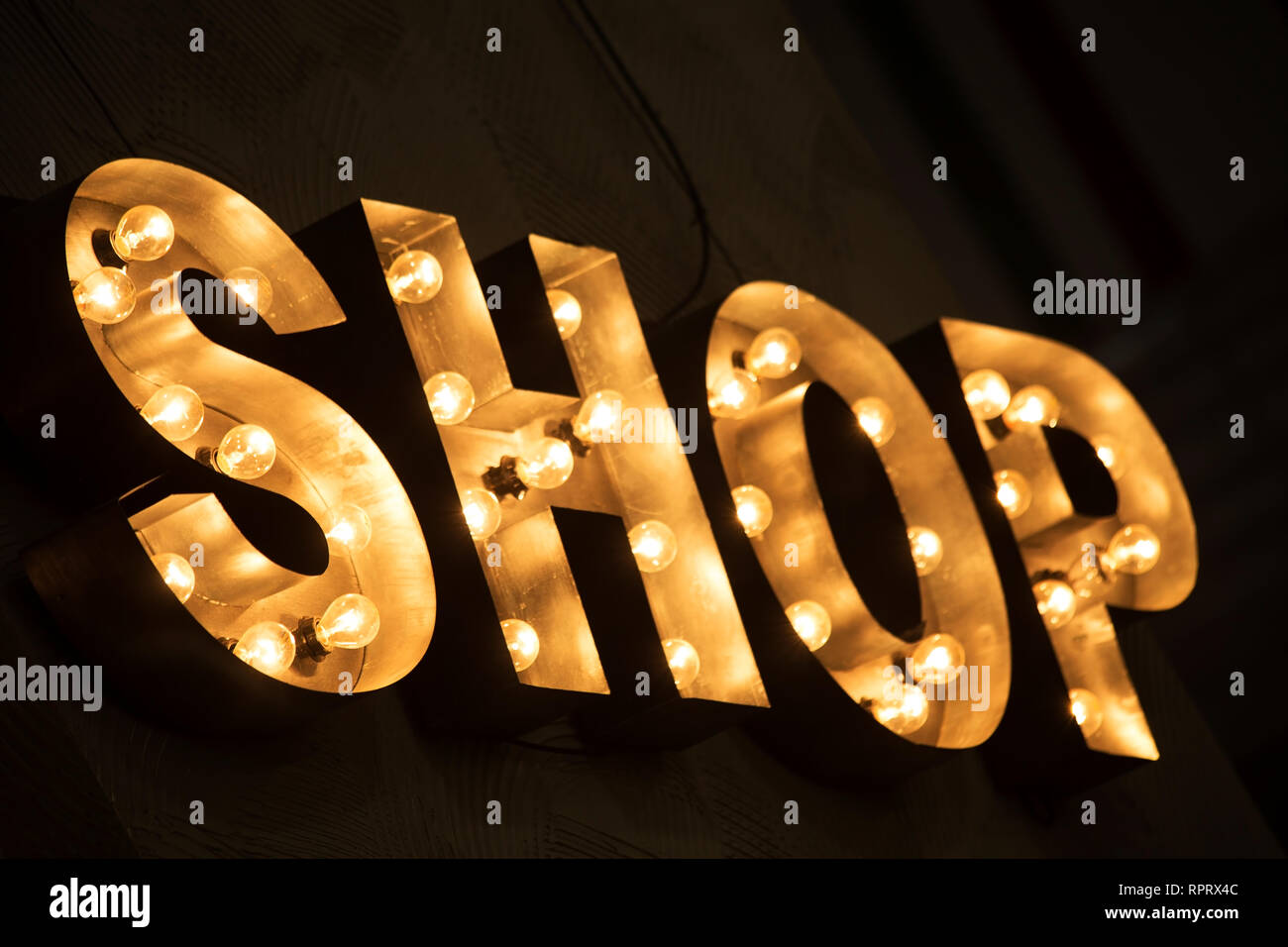 Shining light shop sign on dark background Stock Photo - Alamy