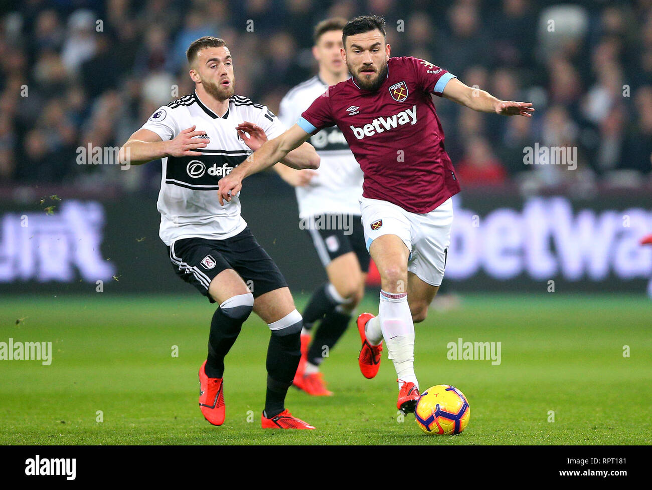 Fulham's Calum Chambers (left) and West Ham United's Robert Snodgrass battle for the ball and during the Premier League match at London Stadium. Stock Photo
