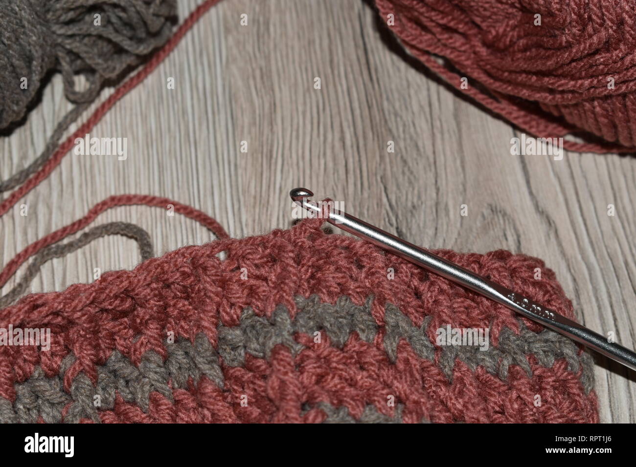 Crochet hook with crocheted beanie. Stock Photo