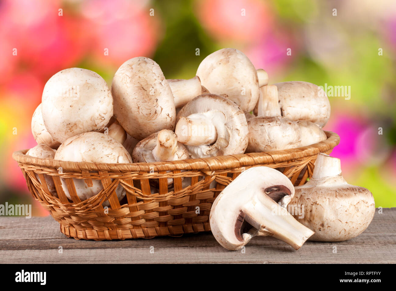 Champignon Mushrooms In A Wicker Basket On Wooden Table With