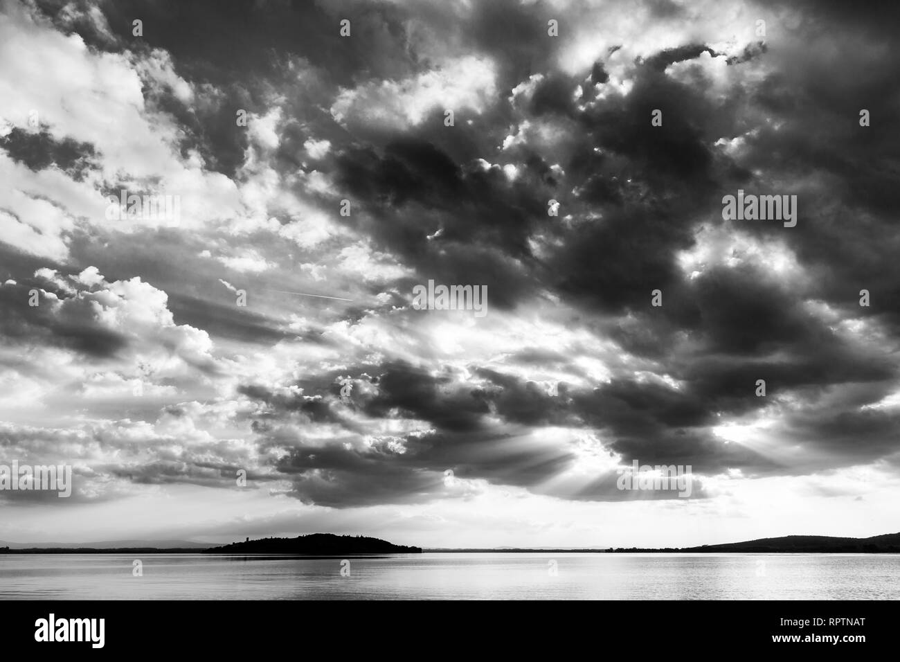 Beautiful wide angle view of a lake with an huge sky with clouds, above an island Stock Photo