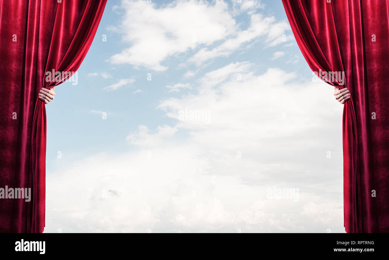 Human hand opens red velvet curtain on blue sky background Stock Photo ...