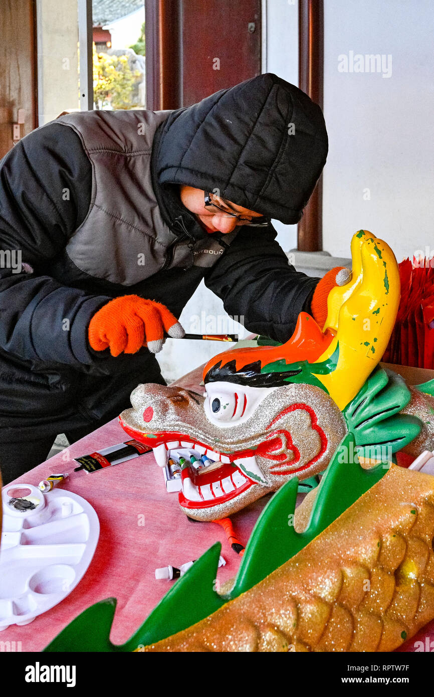 Young man painting Dragon Boat figurehead, Dr Sun Yat Sen Park and Classical Chinese Garden, Vancouver, British Columbia, Canada Stock Photo