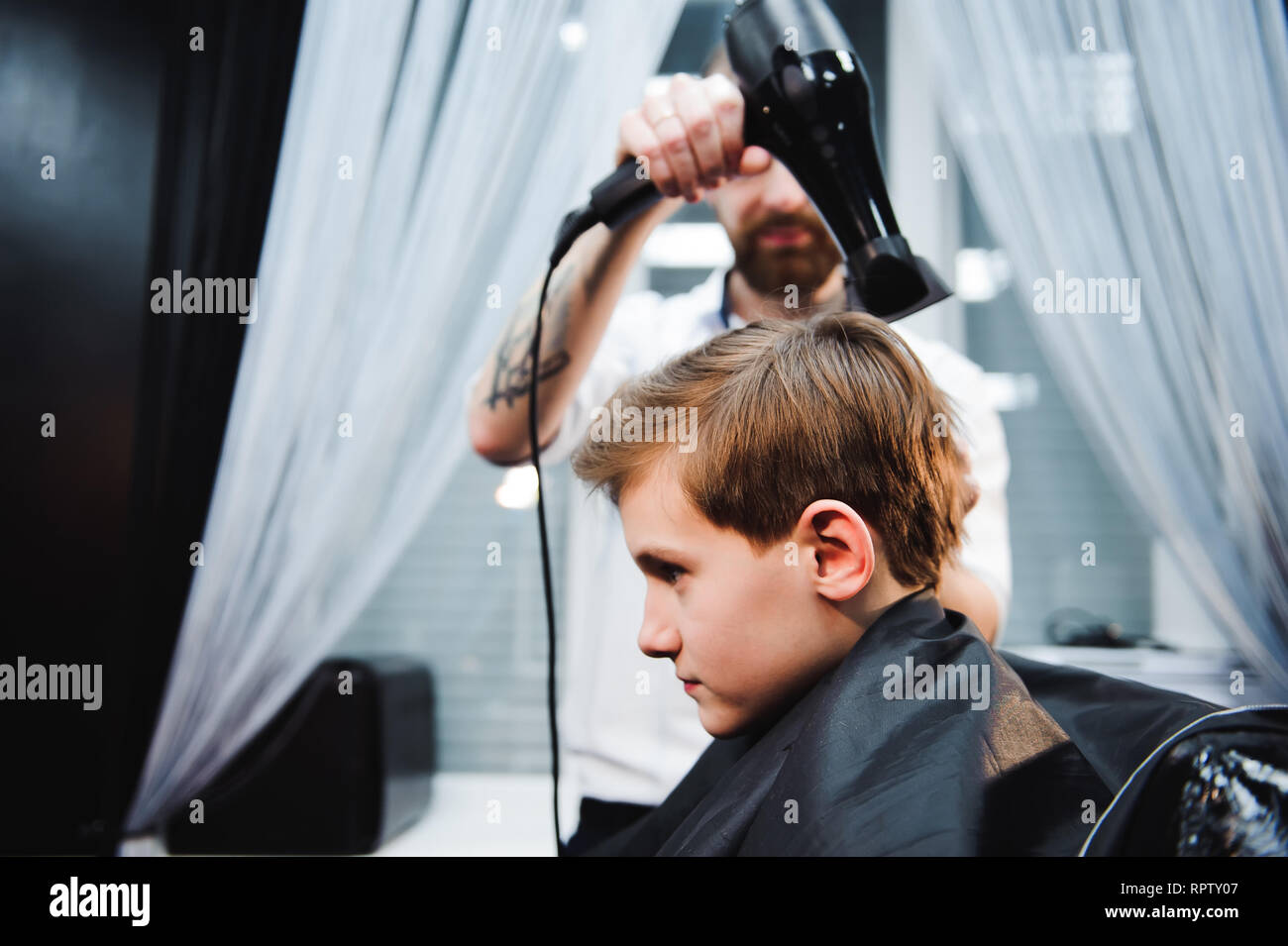Cute Little Boy Is Getting Haircut By Hairdresser At