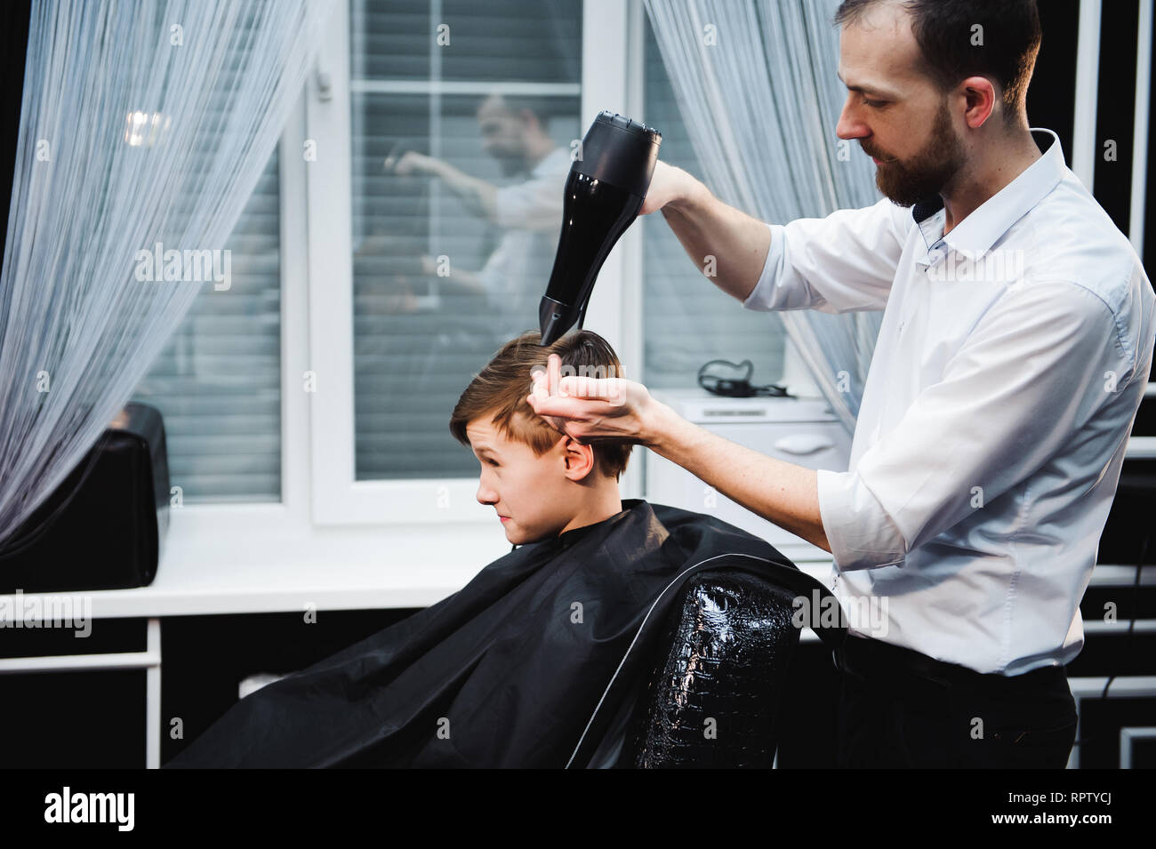Cute Little Boy Is Getting Haircut By Hairdresser At The