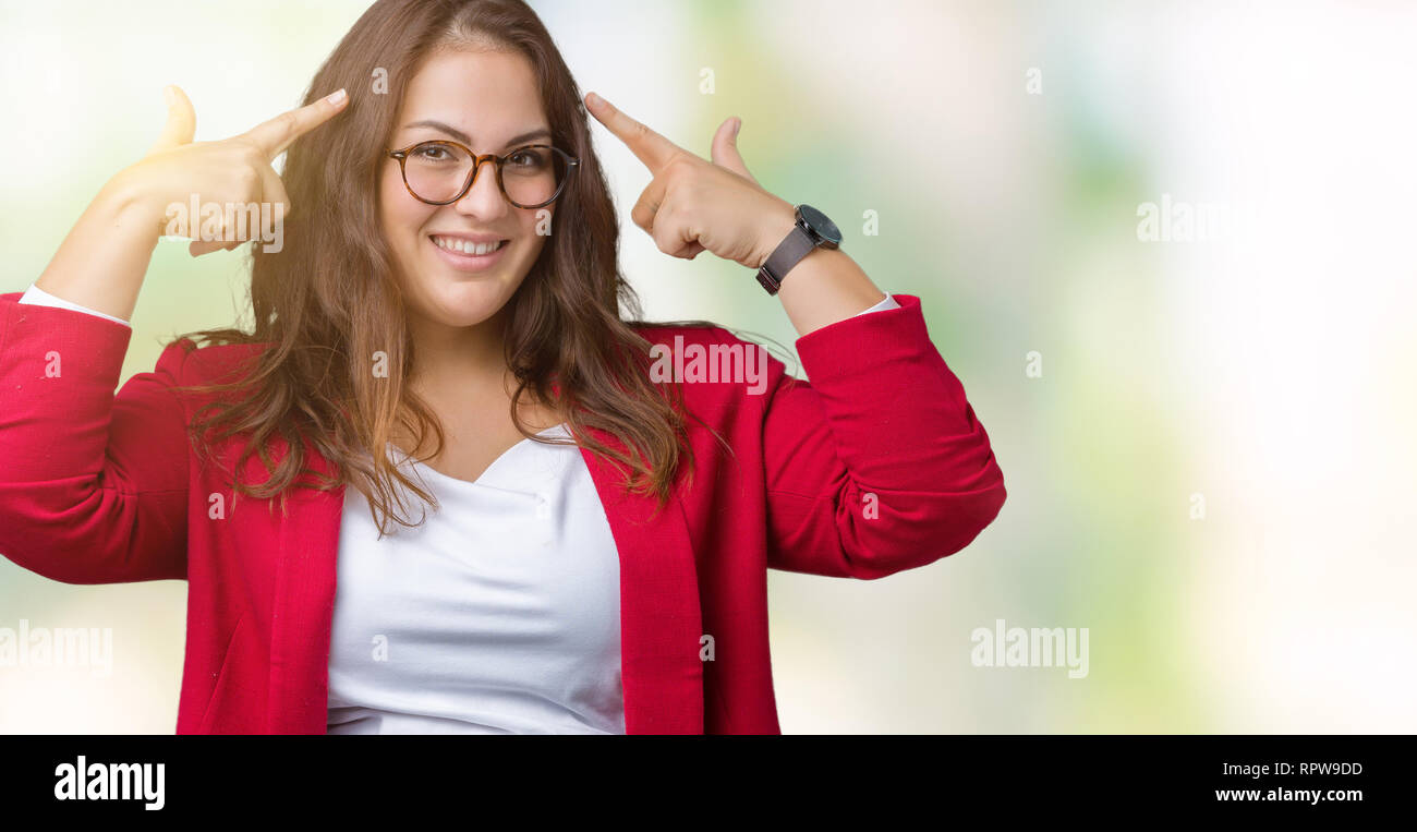 Beautiful plus size young business woman wearing elegant jacket and glasses over isolated background Smiling pointing to head with both hands finger,  Stock Photo