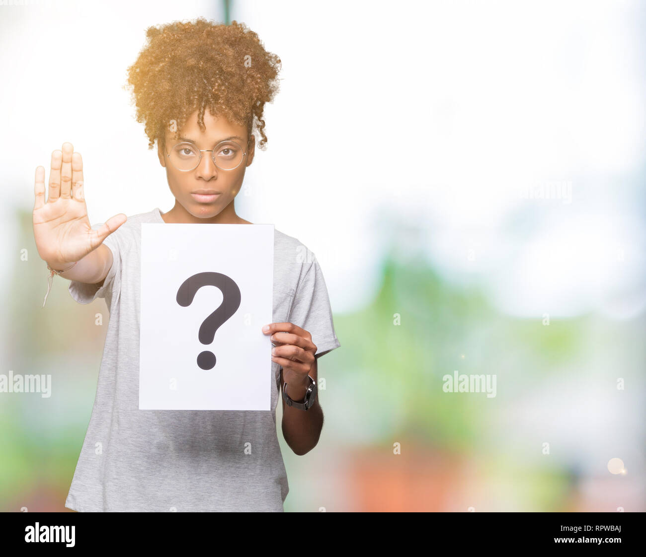 Young african american woman holding paper with question mark over ...