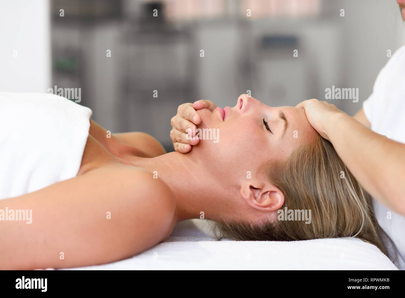Young woman receiving a head massage in a spa center. Stock Photo
