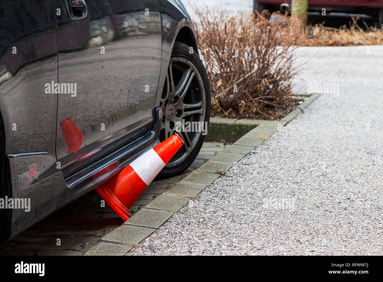 Traffic cone got stuck under black car in parking place Stock Photo Alamy