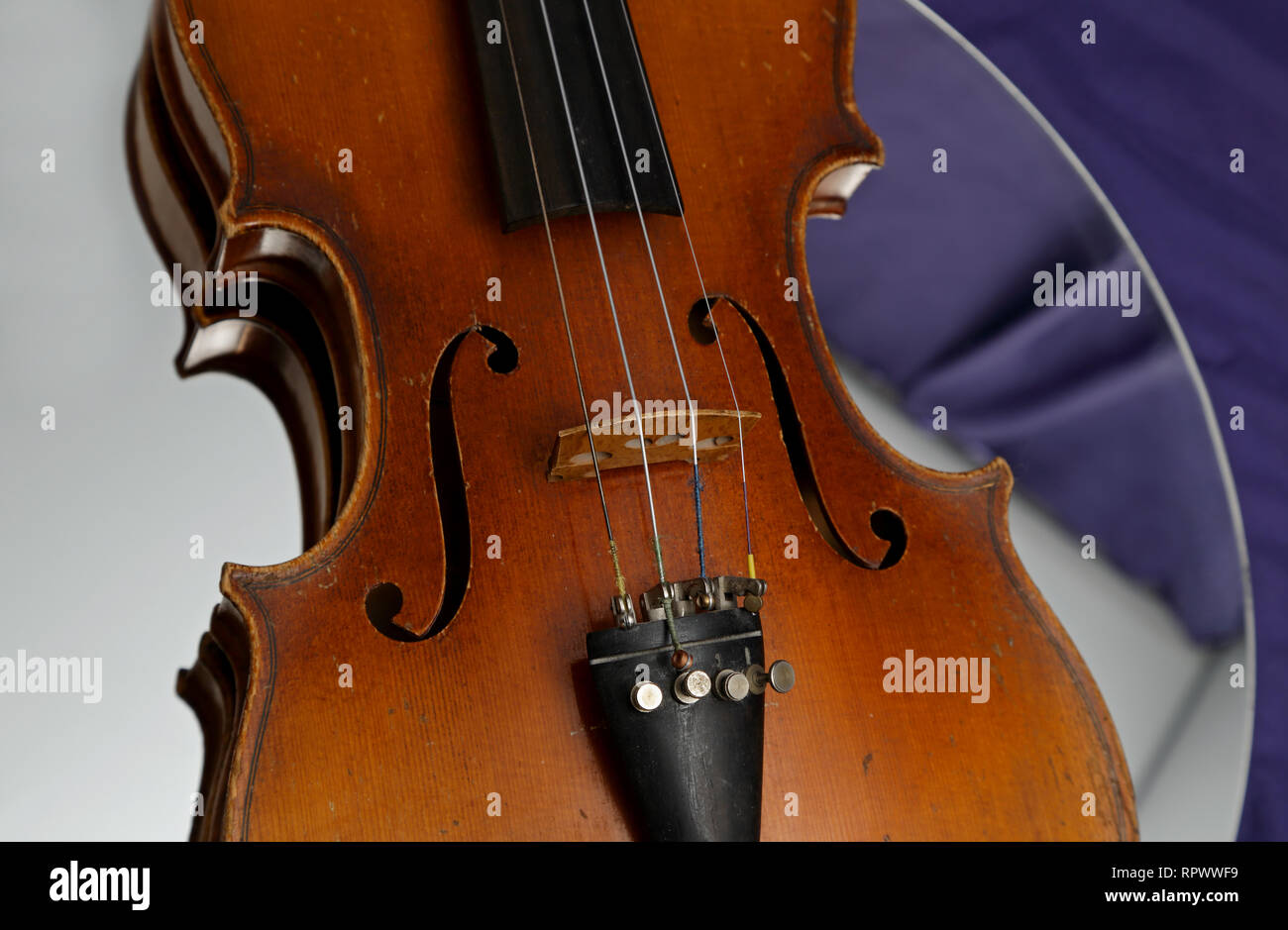 Old and worn out violin on a mirror Stock Photo Alamy