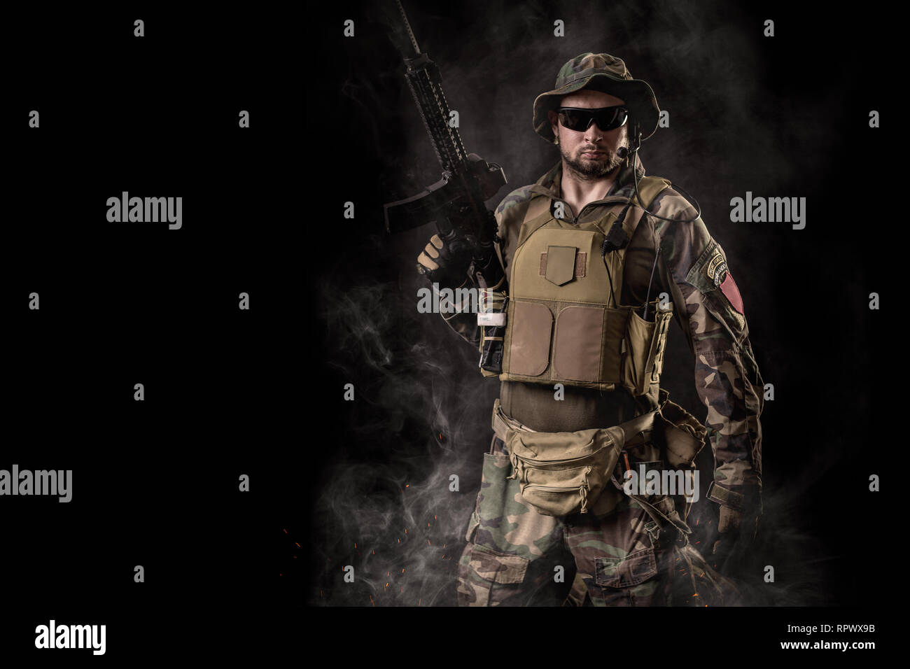 Special Forces soldier with an assault rifle on a black background ...
