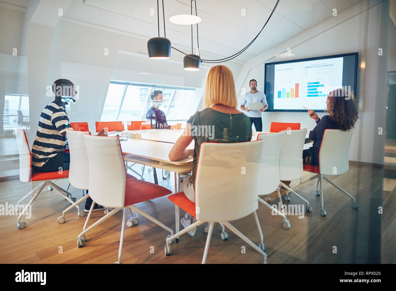 Staff asking questions during a monitor presentation with their manager