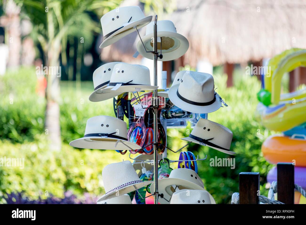 Souvenir vintage Panama hats hung on a stand outside a shop in a beach