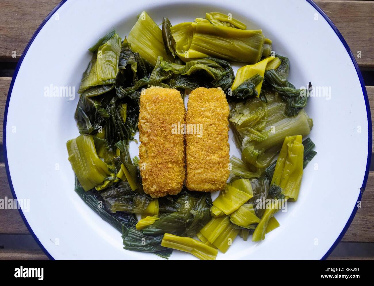 Healthy Meal of Stir Fried Leek Leaves with Fish Fingers Stock Photo