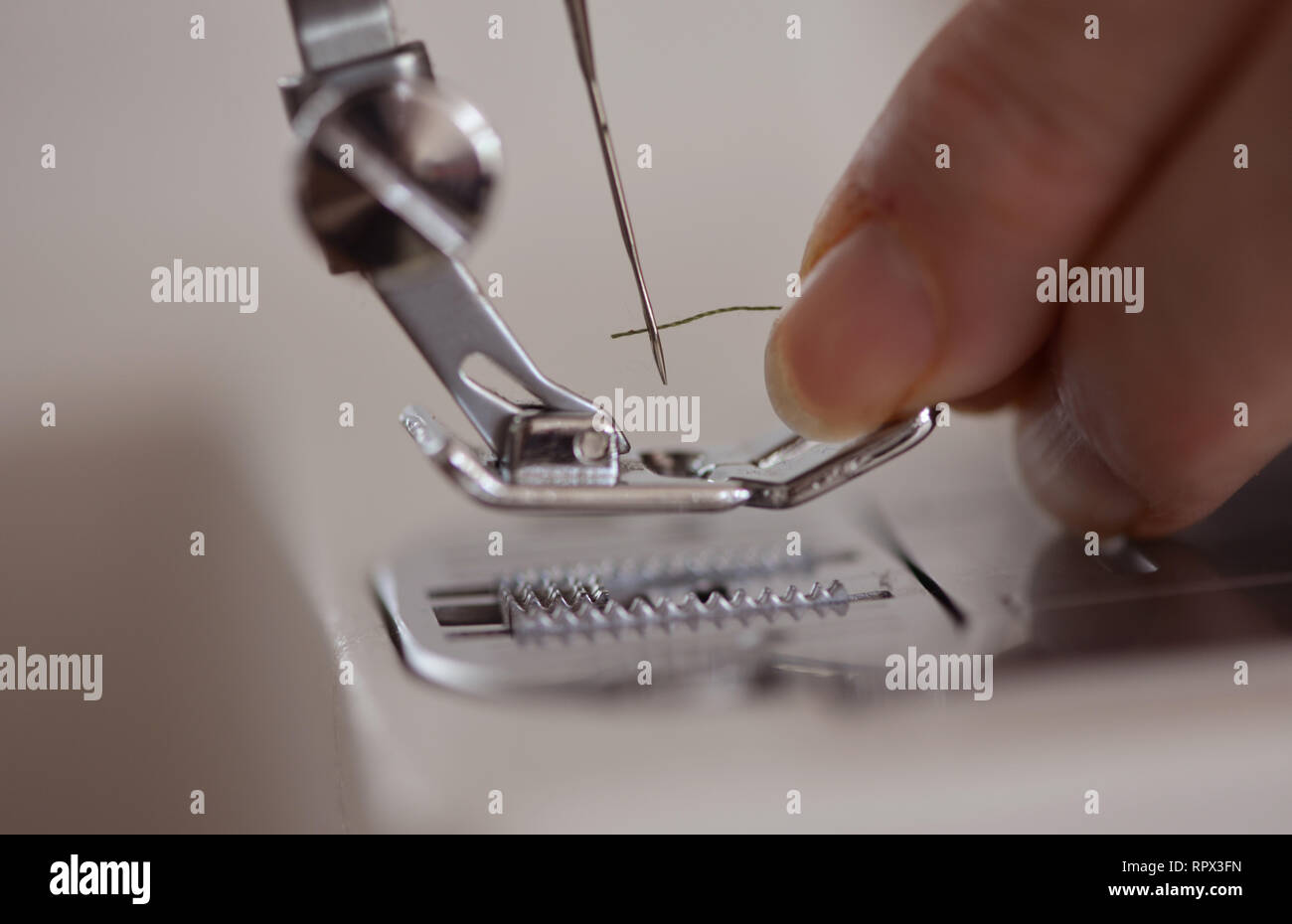 Woman threading a sewing machine needle Stock Photo - Alamy