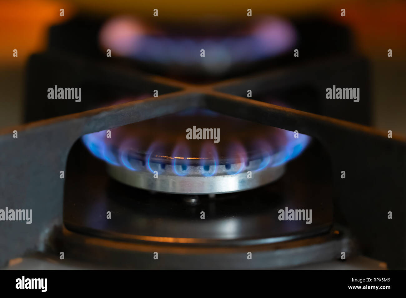 Blue flame of a burning gas stove burner. Closeup, selective soft
