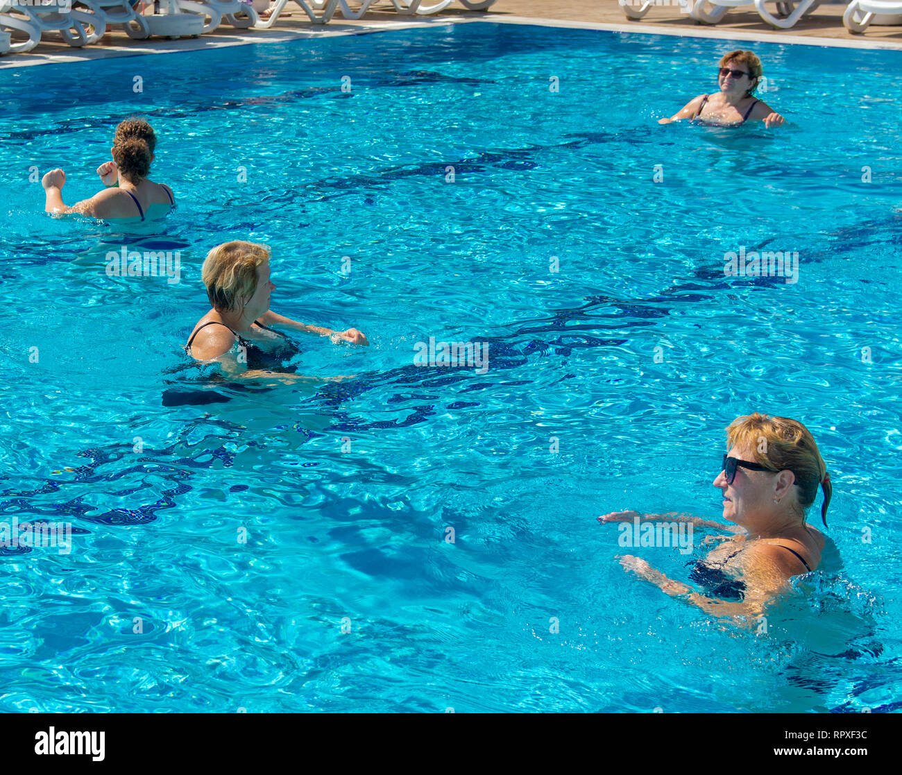 Alanya, Turkey - October 05, 2018. A group of people is engaged in aqua aerobics in the blue clear water of the pool at Kirman Sidera Luxury Spa. Fitn Stock Photo
