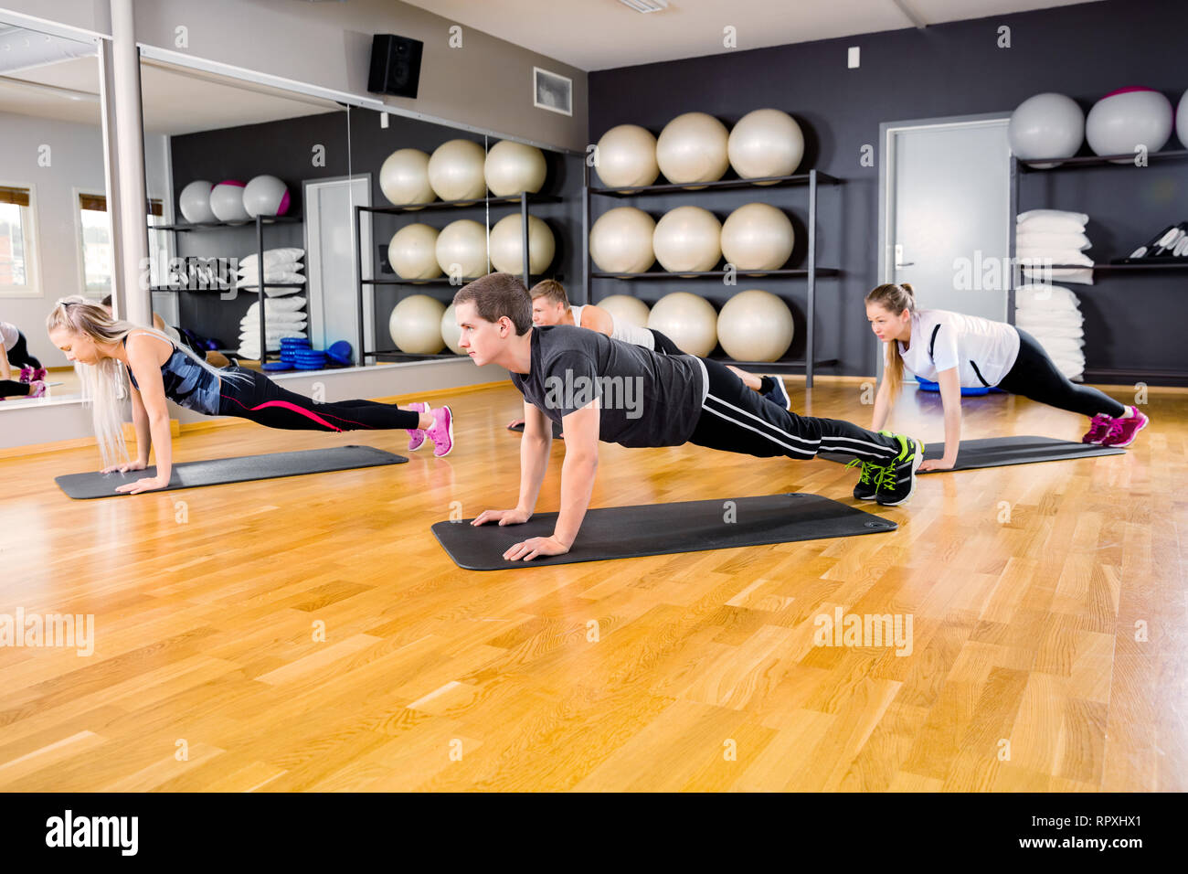 Group of people doing pushups at the fitness gym class Stock Photo