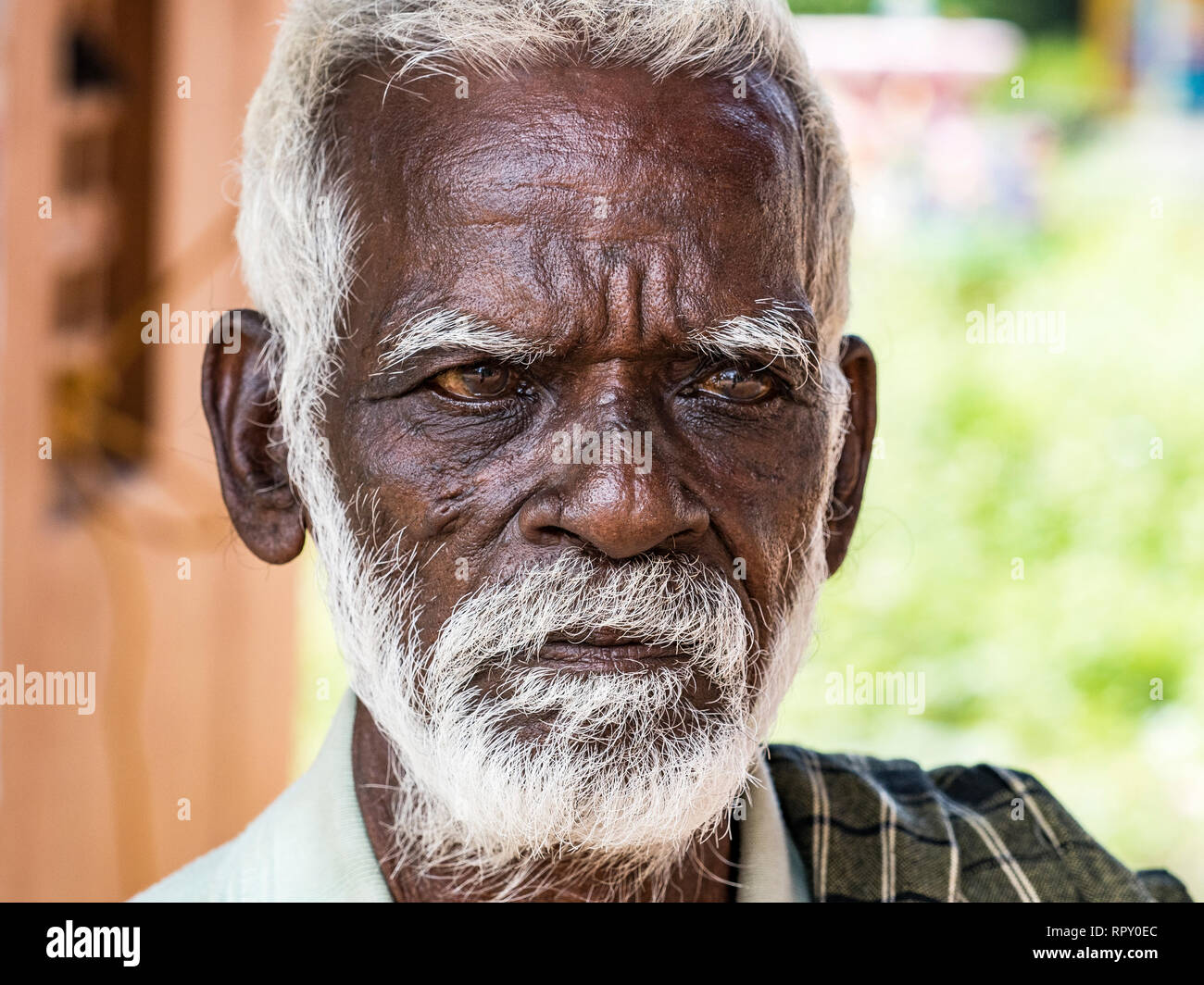 PUDUCHERY, INDIA - DECEMBER Circa, 2018. An unidentifed old senior indian poor man portrait with a dark brown wrinkled face and white hair and a white Stock Photo