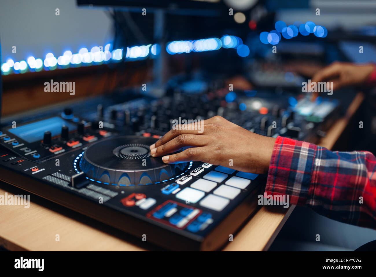 Female sound operator working at the remote control panel in audio